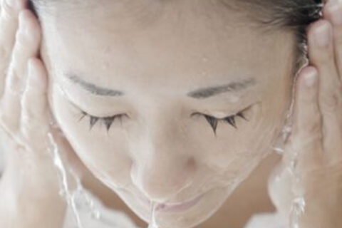 women cleaning her face with water