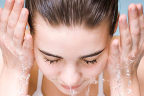 women cleaning her face with water